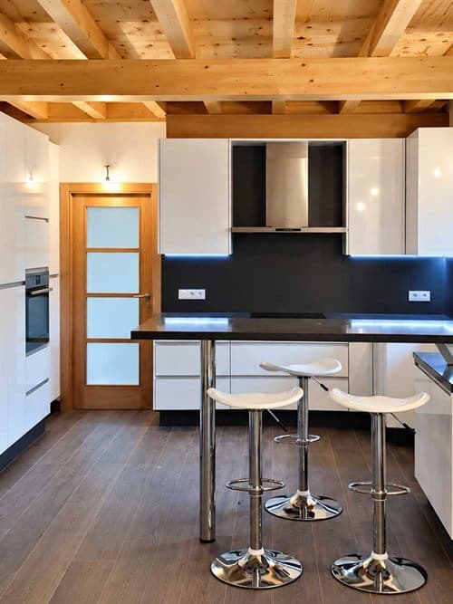 Cocina a medida en blanco con isla y techo de madera en Ferrol